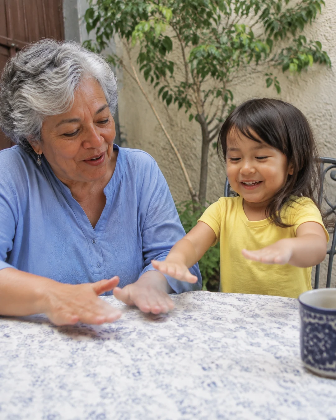 La abuela y su nieta inventan un ritmo en la mesa del patio