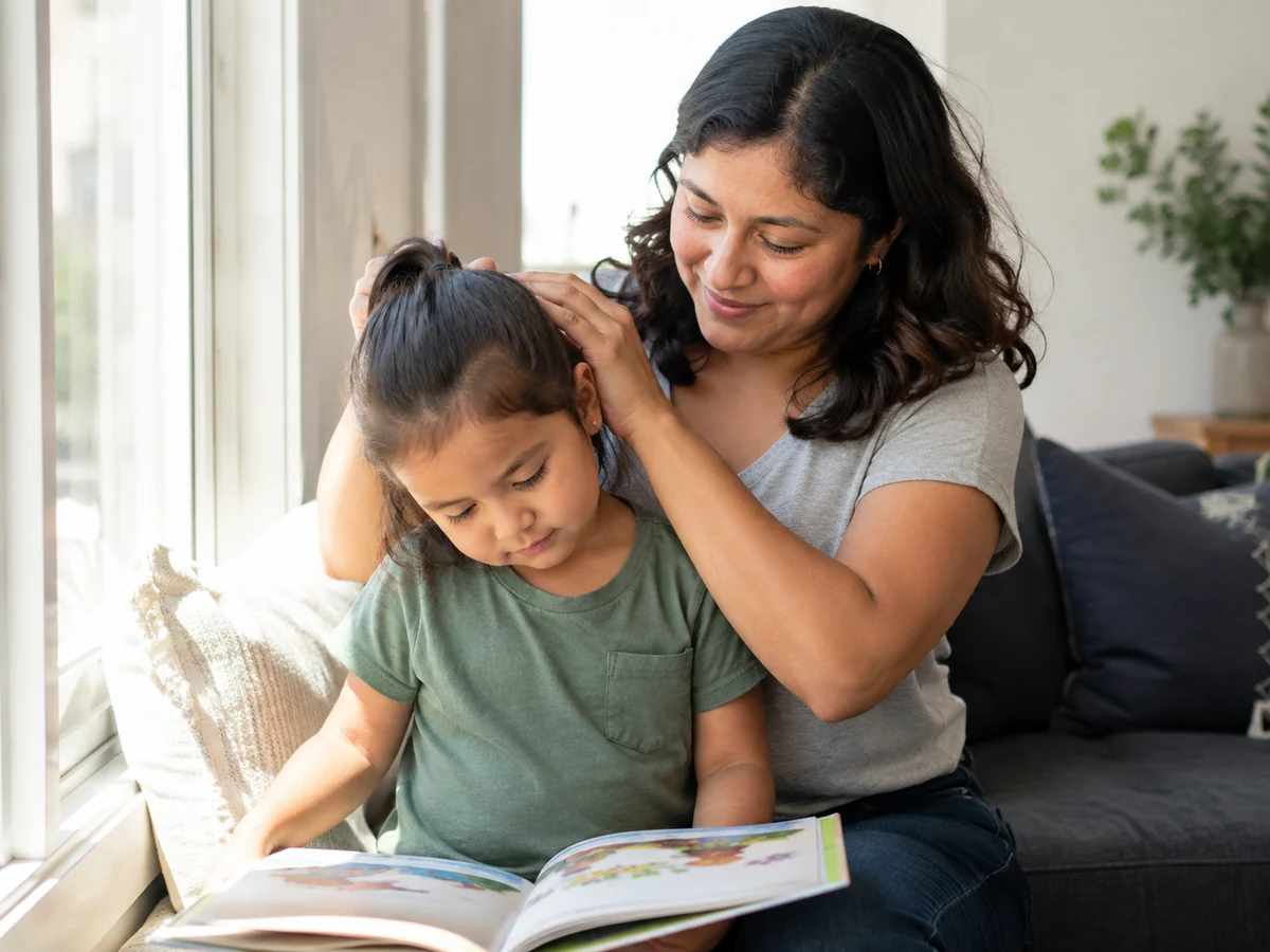 Mom gathers her daughter's hair while she follows a picture book
